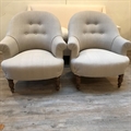 Pair of French tub chairs covered in Taupe linen with a buttoned back and brown turned beechwood legs. C1950.